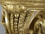 a gold vase with a clock on top of it
