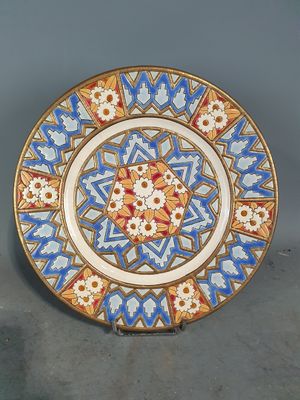 une image représentant une assiette décorative ornée d'un motif bleu et rouge