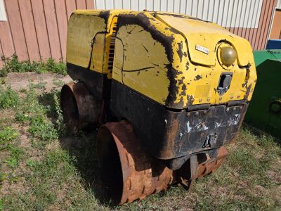 une machine jaune et noire qui est garée dans l'herbe