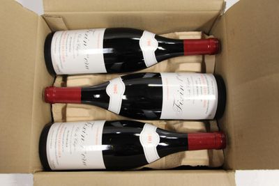 three bottles of wine in a cardboard box on a table