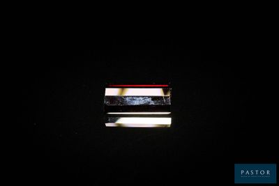 une petite fenêtre dans une pièce sombre, par laquelle pénètre la lumière