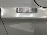 a close up of a silver car with a sticker on it