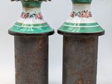pair of green and white vases with floral designs on them