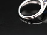 a close up of a diamond ring on a black surface
