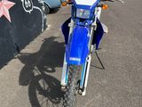 a blue dirt bike parked in front of a building