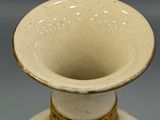 a white vase with a design on it on a table