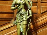 une statue représentant une femme tenant un serpent sur une table