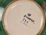 a close up of a green and white bowl with writing on it