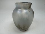 a silver vase that is sitting on a white surface