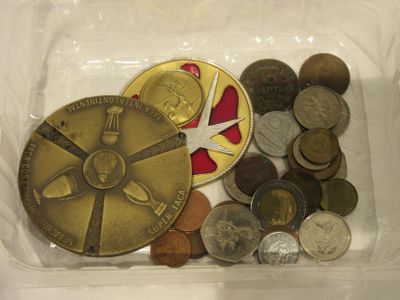 un récipient en plastique rempli de pièces de monnaie et une paire de ciseaux