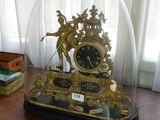 une horloge placée sous un dôme de verre sur une table