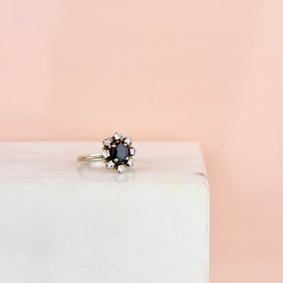 une bague en diamant noir posée sur un bloc de marbre blanc
