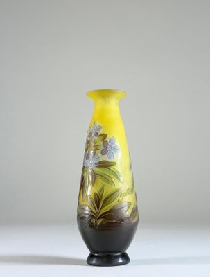 un vase jaune posé sur une table, sur fond blanc