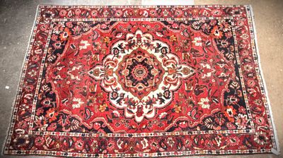a red rug with a medallion design on the middle of it