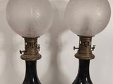pair of black and gold table lamps with frosted glass globes