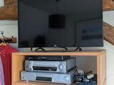 une télévision posée sur une commode dans une pièce au plafond en bois