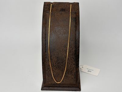 a brown leather jewelry box with a gold chain on it