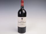 une bouteille de vin rouge posée sur une table blanche, sur fond gris
