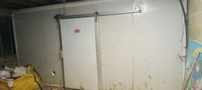une chambre sale avec une porte blanche et un sac poubelle