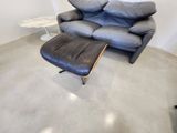 un canapé et un pouf en cuir noir dans un salon