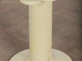 a white pedestal with a candle on top of it