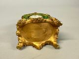 gold plate with a green and gold decoration on top of it