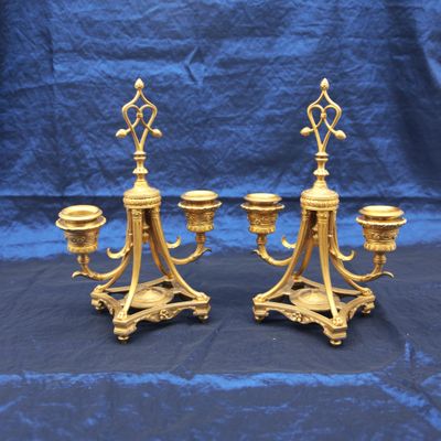 paire de chandeliers anciens en laiton posés sur un socle recouvert d'un tissu bleu