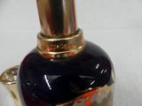 a black and gold vase with a gold top on a white surface