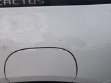 the rear end of a white car with a sticker on it ' s side