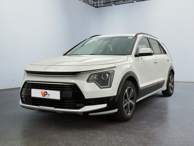 La voiture blanche est garée dans une grande pièce au sol noir.