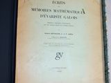 un vieux livre posé sur une table à côté d'un mur