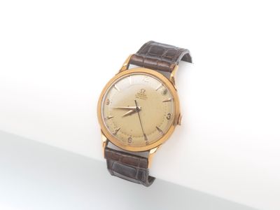 une montre-bracelet en or avec un bracelet en cuir marron