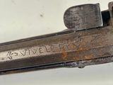 a gun that is on display on a white surface