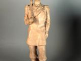 statue of a man with a rifle and a hat on a gray background