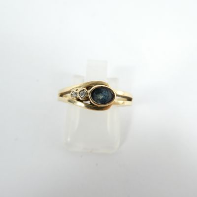 Gros plan sur une bague en or ornée d'un saphir bleu et de diamants