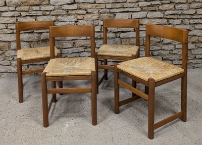 three wooden chairs sitting next to each other in front of a stone wall
