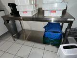 une table en acier inoxydable surmontée de deux bacs