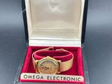 une montre en or dans un coffret noir orné d'un ruban rouge