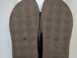 a close up of a pair of brown shoes on a white surface