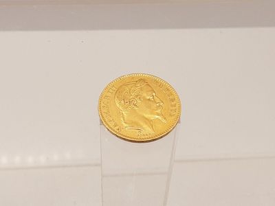une pièce d'or posée sur une vitrine transparente