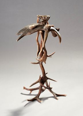 une sculpture représentant un oiseau perché sur une branche d'arbre