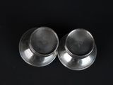 pair of silver plated salt and pepper shakers on a black background