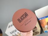 a person holding a brown box with a black label on it