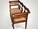 an old wooden chair with a seat made of wood