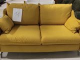 un canapé jaune avec des coussins dessus, dans un magasin