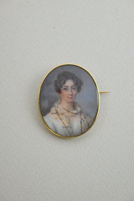 an antique portrait of a woman in a white dress is shown in a gold plated pin