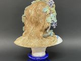 an image of a ceramic bust of a woman with grapes on her head