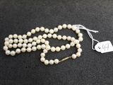 un collier de perles blanches muni d'une étiquette