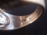 a close up of a silver ring with a diamond on it