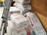 une échelle posée à côté d'une pile de sacs de ciment